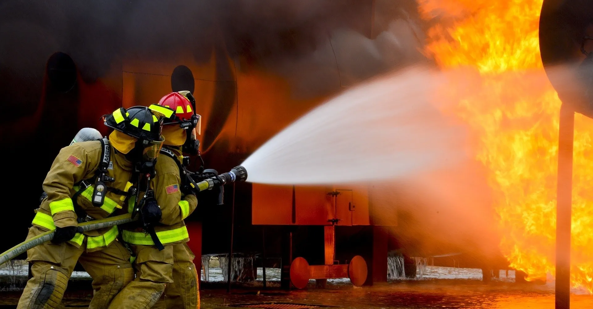 Firefighters extinguishing a large industrial fire.