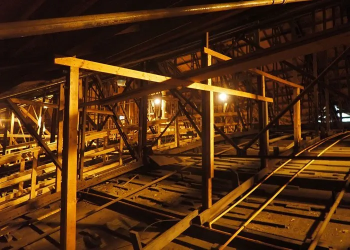 Dimly lit attic with wooden beams and rafters.